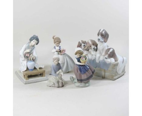 A collection of Lladro and Nao figures, to include a group model of puppies23w x 11d x 22h cm