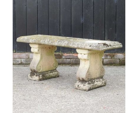 A reconstituted stone garden bench, on scrolled supports113w x 39d x 46h cm