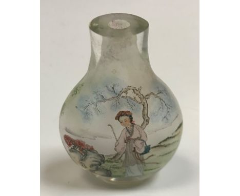 A Chinese glass flask shaped snuff bottle decorated with woman by tree and woman in a garden setting, signed, 6.5 cm x 4.5 cm