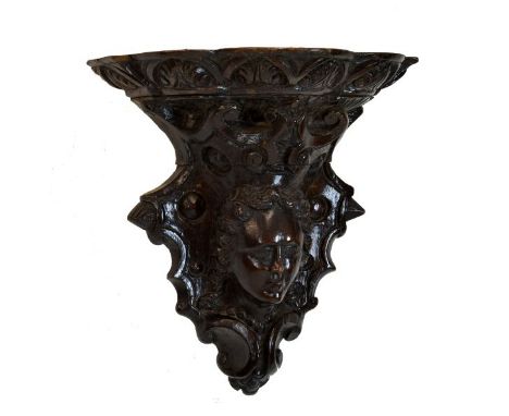 Interesting carved wooden figural wall bracket, probably 18th Century, the three-lobed shelf with foliate palmette edge carvi