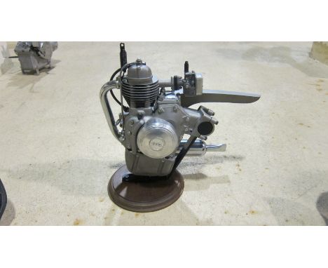 A Motomic clip-on motorcycle enginefitted with a carburettor and exhaust system, engine number L*263565*, mounted on base, co