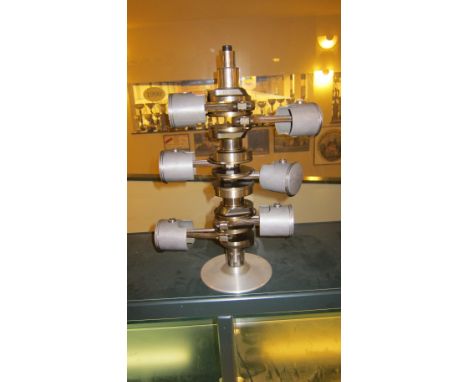 A display crankshaft assemblywith conrods and pistons attached, mounted on base, believed to be for an unidentified V6 engine