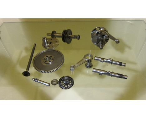 An unidentified selection of engine componentsincluding a crankshaft, bevel drive gears, conrod and sundry parts, close inspe