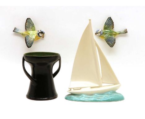 A pair of Beswick wall mounted birds 12cm wide, a Poole Pottery model of a sailing vessel, 26cm high and an Art Pottery Devon