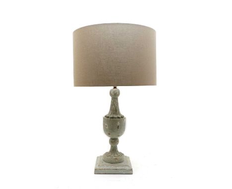 A contemporary table lamp, with a carved and turned wooden base, with distressed blue plaint, on a faceted base, with a drum 