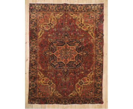A Persian wool carpet, mid-20th century, Heriz, woven with geometric foliate motifs on a red ground, 374 x 300 cmCondition re