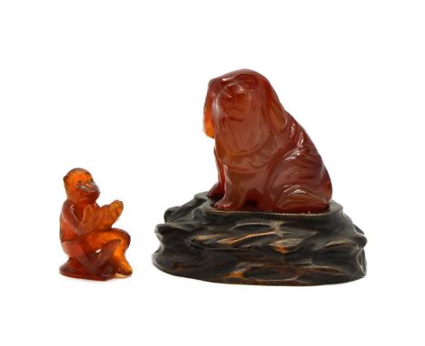 A Chinese agate carving, of a dog, 5cm tall, wood stand, and an amber monkey, 3.2cm high (3)Condition report: Dog - minute ch