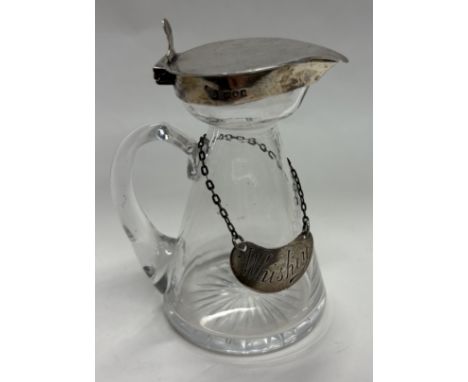 A silver mounted glass whisky noggin with kidney-shaped label. London 1910. Est. £120 - £150.