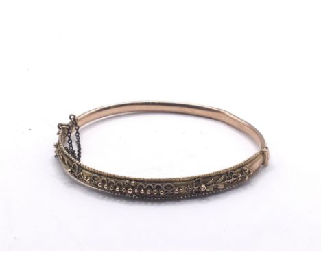 A 9carat gold bangle with raised decoration. Weight 5.5g