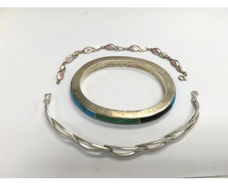 A silver bangle set with malachite, turquoise and onyx together with two silver bracelets (3).