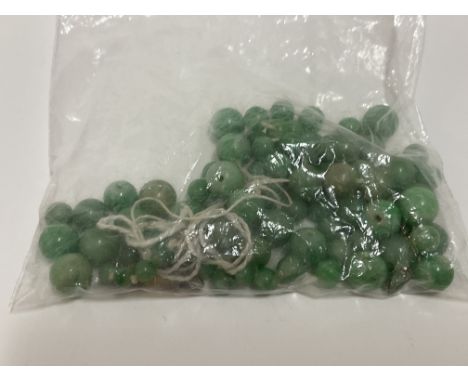 A collection of unstrung apple green jade beads.