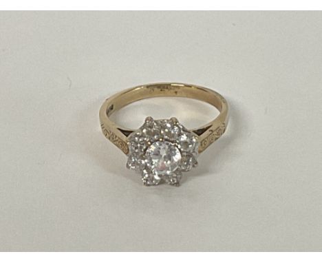 A multi stone cluster ring with engraved shoulders in 9ct Gold, size R.