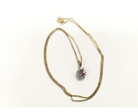 An oval ruby and diamond cluster pendant on a gold chain, approx 2.4g.