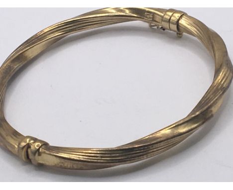 A 9carat gold twist and clip close bangle weight 7g
