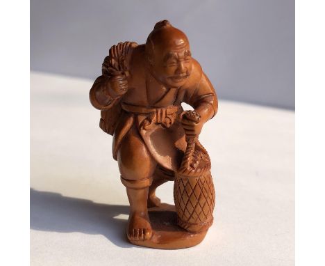 JAPANESE NETSUKE OF A FISHERMAN CARRYING A POT