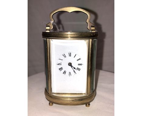 A MINATURE OVAL 4PANE GILT METAL CARRIAGE CLOCK 11CM HIGH 