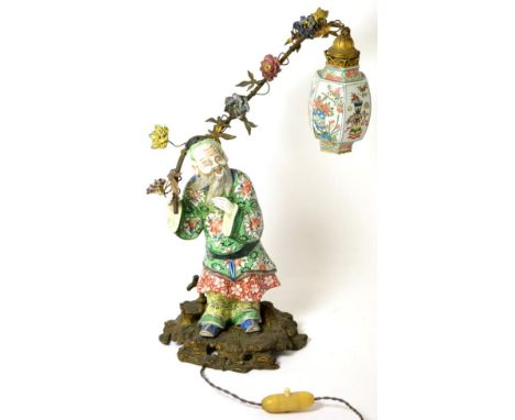 A Gilt Metal Mounted Porcelain Lamp Base, in Chinese style, as a bearded figure in traditional robes painted in famille verte