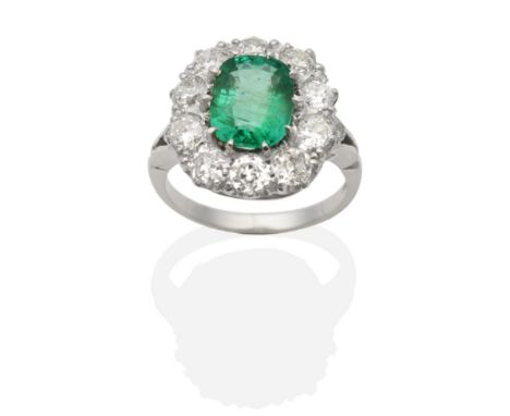 An Emerald and Diamond Cluster Ring, a cushion cut emerald within a border of old cut diamonds in claw settings, to diamond s