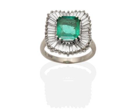 An Emerald and Diamond Cluster Ring, an octagonal cut diamond in a claw setting within an undulating border of tapering bague