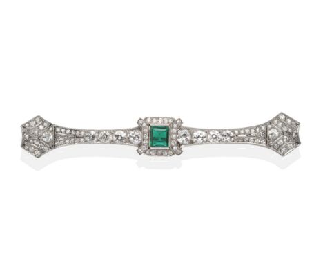 An Art Deco Emerald and Diamond Bar Brooch, a step cut emerald to a tapering bar set throughout with old cut diamonds in milg