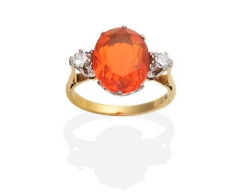 A Fire Opal and Diamond Three Stone Ring, an oval cut fire opal between two round cut diamonds in claw settings, to knife edg