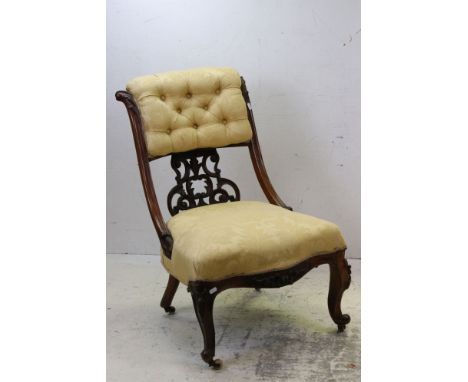 Victorian Mahogany Low Salon Chair upholstered in yellow buttoned fabric with ornately carved splat and raised on carved scro
