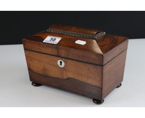 Georgian Rosewood Tea Caddy of sarcophagus form, the hinged lid opening to two lidded compartments, raised on ball feet, 22cm