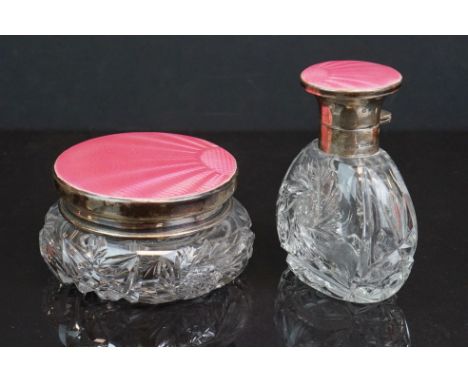 Two cut glass dressing table jars with fully hallmarked sterling silver lids with pink guilloche enamel decoration, maker mar