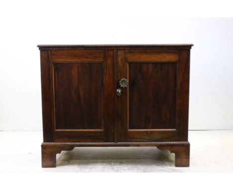 19th century Rosewood Cabinet with gadrooned edge, the two panel doors opening to shelves, raised on bracket feet, 97cms wide