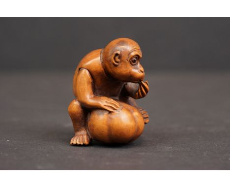 A caved Netsuke in the form of a monkey with character marks to base. 