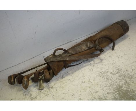 A quantity of vintage gold clubs in a vintage golf bag. 
