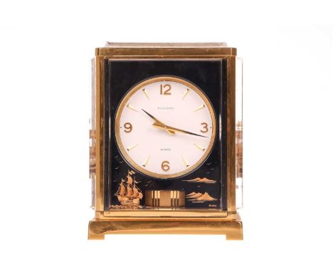 A Jaeger LeCoultre 'Marina' Atmos clock, the blacked perspex panels depicting sailing ships, the white dial with gilt batons 