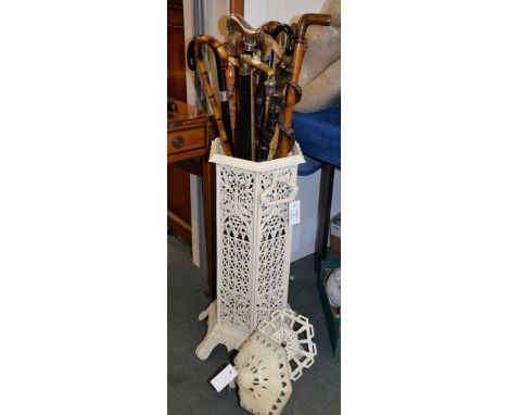 A white painted cast iron stick stand, of hexagonal section and a quantity of various sticks 