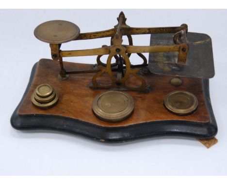 Set of antique brass postal scales with weights, on a walnut stand. 