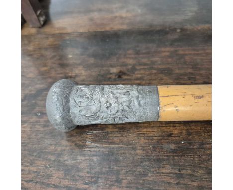 A Mallaca walking cane with a white metal oriental design handle. 