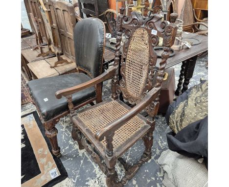 An 18th-century carved oak cane-backed armchair. 