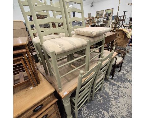 A pine kitchen table and six matching ladder-back dining chairs. 
