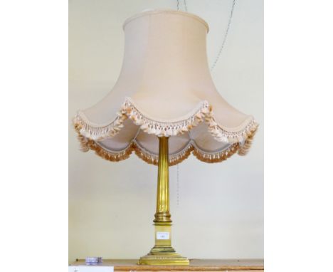 A brass columnar table lamp with coloured tasseled shade