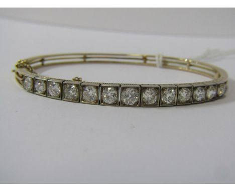 YELLOW METAL (TESTS HIGH CARAT GOLD) DIAMOND SET BANGLE, bright well matched old cut diamonds totalling in excess of 2ct in 3