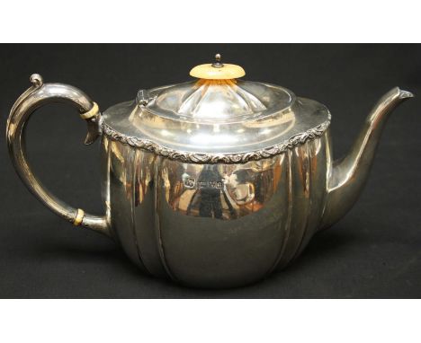 An Edwardian silver teapot, hallmarked Chester 1903, with moulded, scrolling decoration to top edge, ivory finial and ivory b