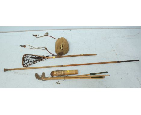 A set of golf clubs, together with a blow pipe and quiver of darts, a lacrosse stick, and a floor-to-ceiling boxing ball.