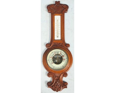 A small oak aneroid banjo barometer, with thermometer and carved case.