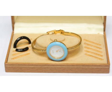 A ladies Gucci quartz wristwatch in yellow metal case with a plain white dial and interchangeable bezel feature (no spare bez