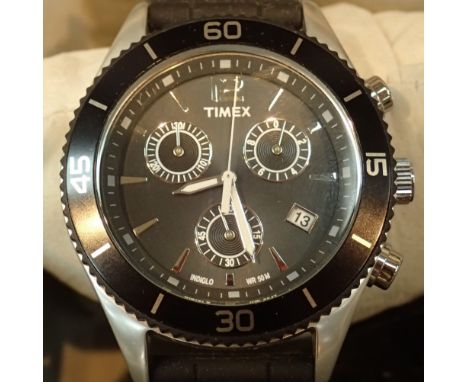 Boxed new old stock gents stainless steel Timex wristwatch with black bezel and black rubber strap  CONDITION REPORT: This it