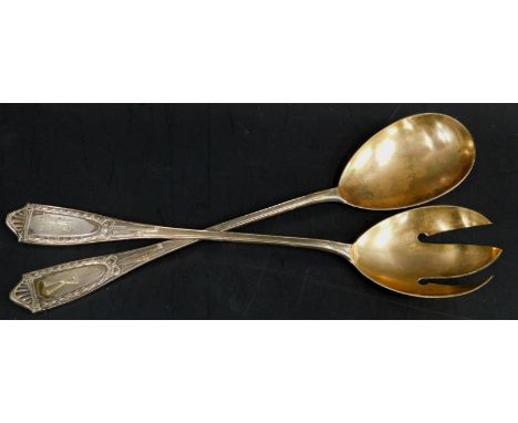 A pair of German white metal salad servers, each with tapering handles, engraved with the initial R, gilt bowls stamped 800, 