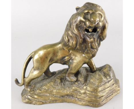 A cast brass model of a lion, on a stylised rock base, lacking plinth, 19cm wide
