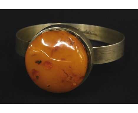 A butterscotch amber set silver bangle, white metal stamped 925, with marks inside