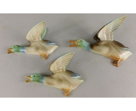 A graduated set of three Art Deco Poole pottery flying ducks, designed by John Adams, the largest 18cm long