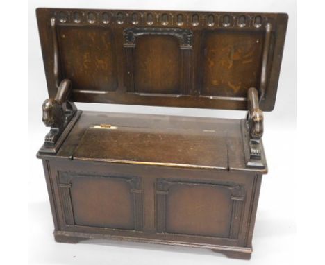 An oak monk's type bench, with a panelled top and hinged lid, on bracket feet (AF), 106cm wide