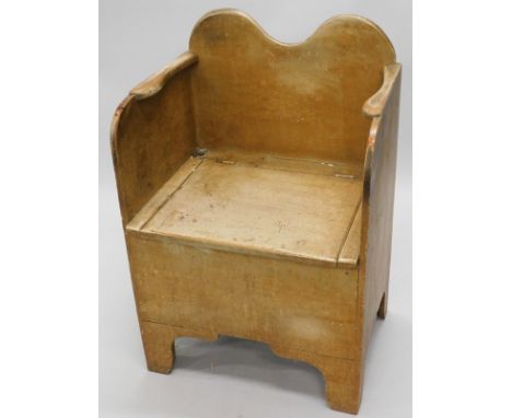 A 19thC painted pine commode chair, with a shaped back and arm rests, the hinged lid revealing a cupboard recess and chamber 